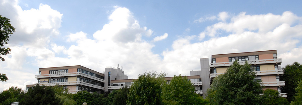 Emil-Figge-Straße 50 mit Wolken und grünen Bäumen im Hintergrund 