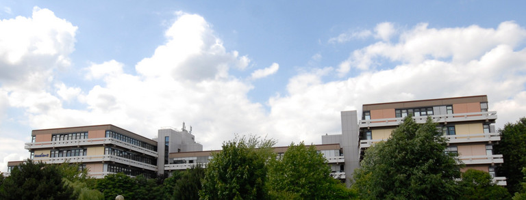 Emil-Figge-Straße 50 mit Wolken und grünen Bäumen im Hintergrund 